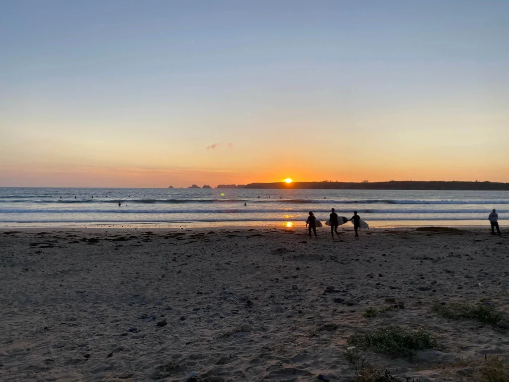 Surfeurs sur la plage de Goulien en presqu'île de Crozon au soleil couchant